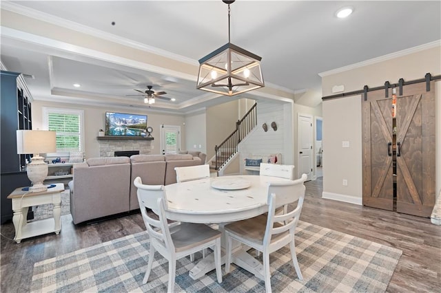 3392 Fall Branch Ln, Buford, GA 30519 - dining space featuring a barn door, wood finished floors, stairs, a fireplace, and ceiling fan
