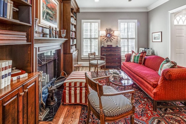 living room with crown molding, a fireplace, and wood finished floors