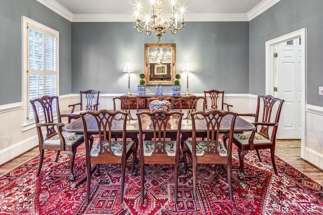 dining room with ornamental molding, baseboards, an inviting chandelier, and wood finished floors