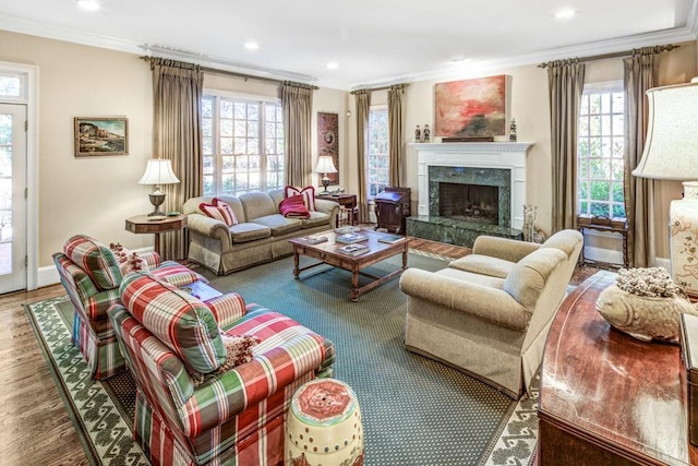 living room with a fireplace, ornamental molding, a wealth of natural light, and wood finished floors