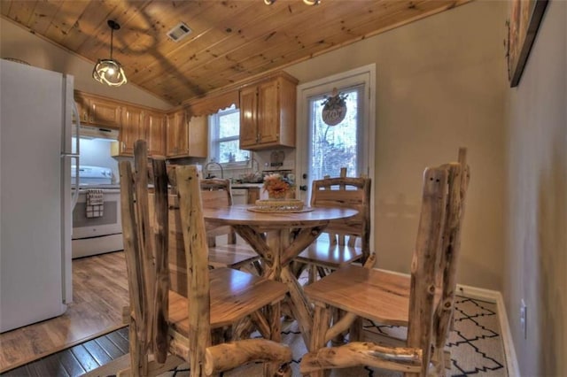 dining room featuring vaulted ceiling, light wood-style flooring, wood ceiling, and visible vents