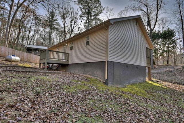 back of property with a deck and fence