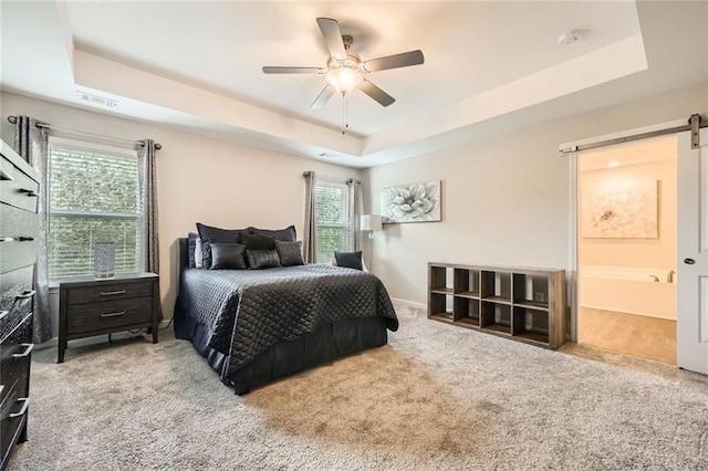 3070 Fareed St, Douglasville, GA 30135 - carpeted bedroom with a barn door, a raised ceiling, and ceiling fan