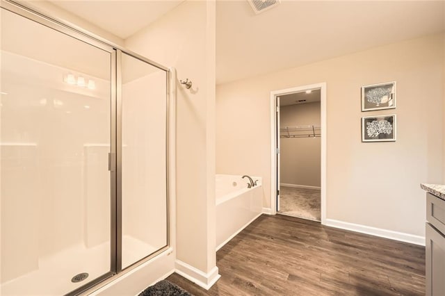 3070 Fareed St, Douglasville, GA 30135 - full bath with a stall shower, wood finished floors, a garden tub, and baseboards
