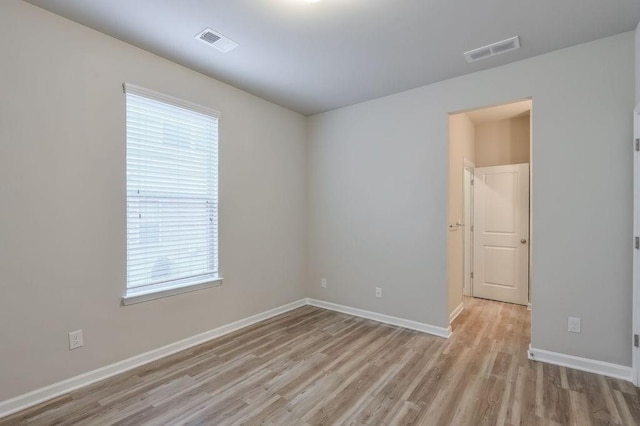 spare room featuring a healthy amount of sunlight and light hardwood / wood-style flooring