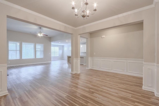 empty room featuring ceiling fan with notable chandelier, light hardwood / wood-style floors, and ornate columns