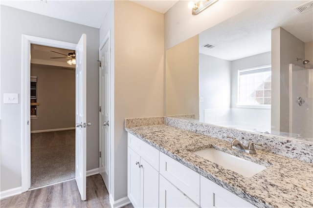 bathroom featuring a shower, wood finished floors, vanity, and visible vents