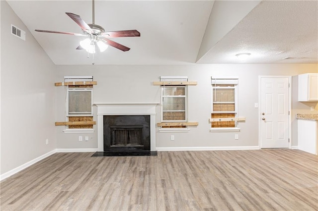 unfurnished living room featuring visible vents, baseboards, lofted ceiling, light wood-style flooring, and a fireplace