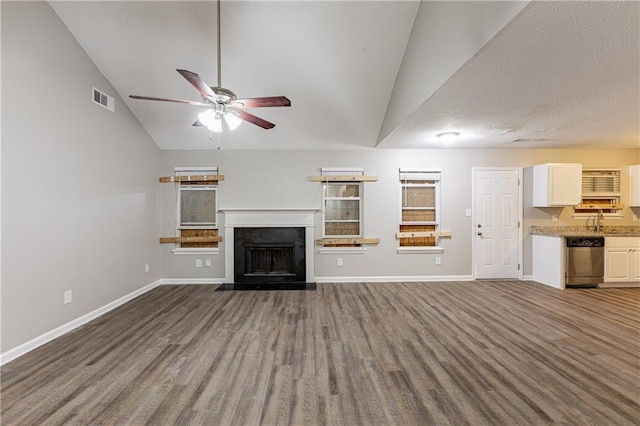 unfurnished living room with baseboards, visible vents, a ceiling fan, lofted ceiling, and a fireplace with flush hearth