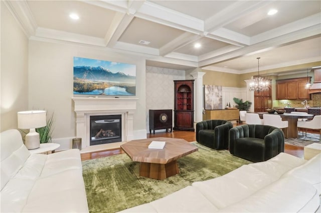 living room with crown molding, an inviting chandelier, beam ceiling, decorative columns, and coffered ceiling