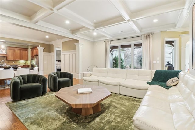 living room with coffered ceiling, beam ceiling, wood-type flooring, and ornate columns