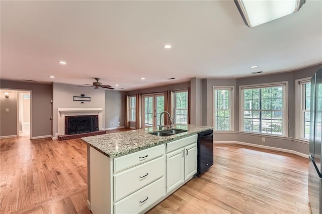 245 Sutallee Ridge Ln NE, White, GA 30184 - kitchen featuring dishwasher, a sink, open floor plan, baseboards, and light wood-type flooring