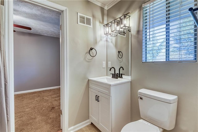 bathroom with vanity, toilet, and a textured ceiling