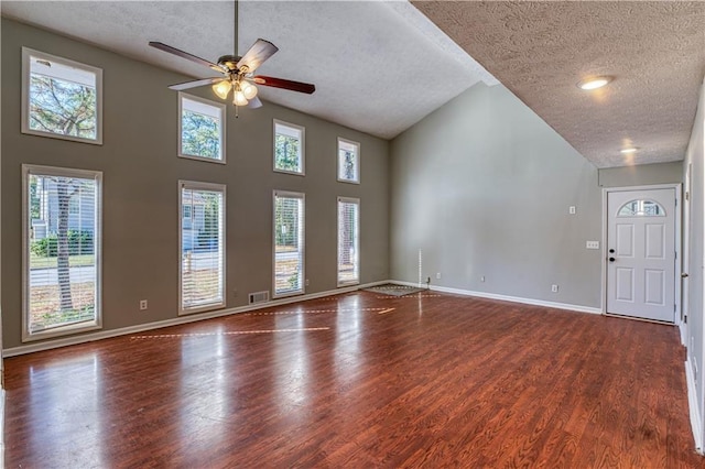 unfurnished living room with hardwood / wood-style flooring, ceiling fan, a textured ceiling, and high vaulted ceiling