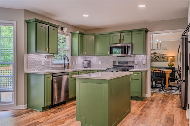 kitchen with green cabinets, light countertops, stainless steel appliances, and light wood-style flooring