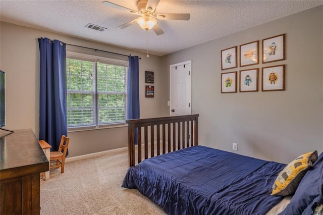 carpeted bedroom with baseboards, ceiling fan, visible vents, and a textured ceiling