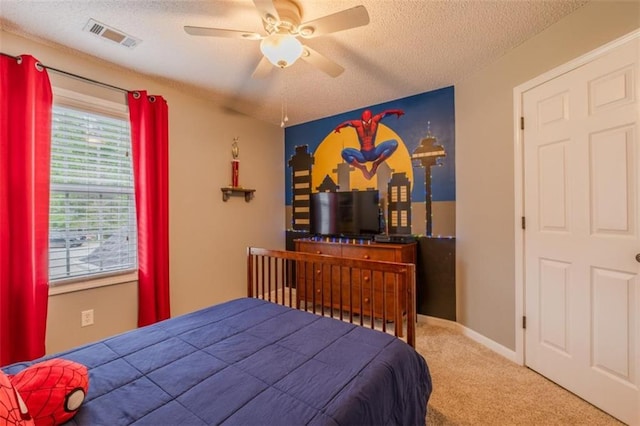bedroom with ceiling fan, a textured ceiling, carpet floors, and visible vents