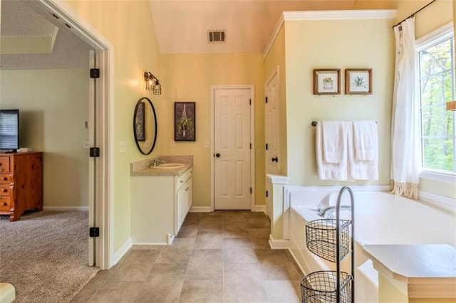 full bath with vanity, a tub to relax in, baseboards, and visible vents