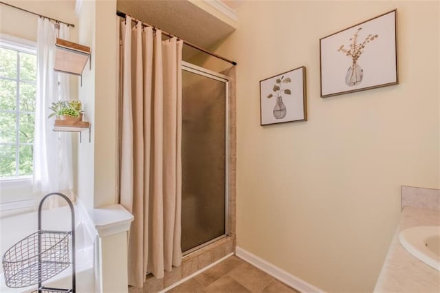 full bathroom with baseboards, tile patterned flooring, a healthy amount of sunlight, and curtained shower