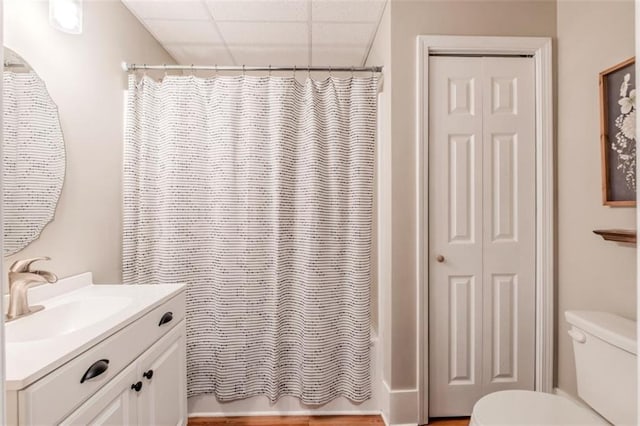 full bathroom with a paneled ceiling, vanity, toilet, and shower / bathtub combination with curtain