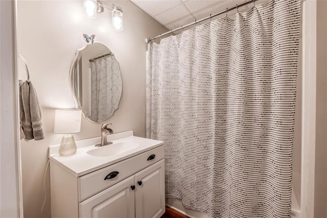 full bath with a drop ceiling, vanity, and shower / bathtub combination with curtain