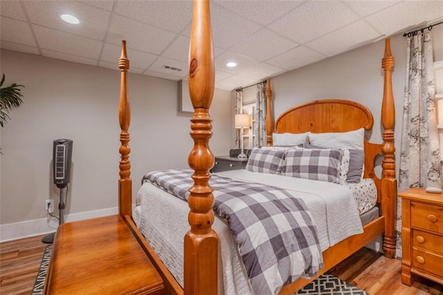 bedroom featuring a paneled ceiling, recessed lighting, visible vents, and wood finished floors