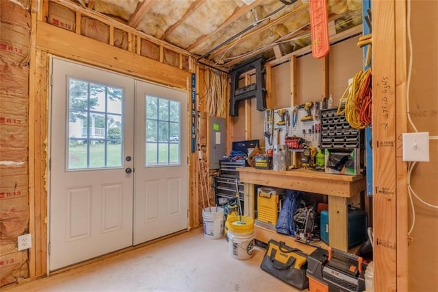 interior space with electric panel, concrete floors, and a workshop area