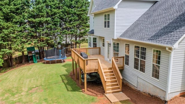 exterior space with stairway, fence, a trampoline, and a yard