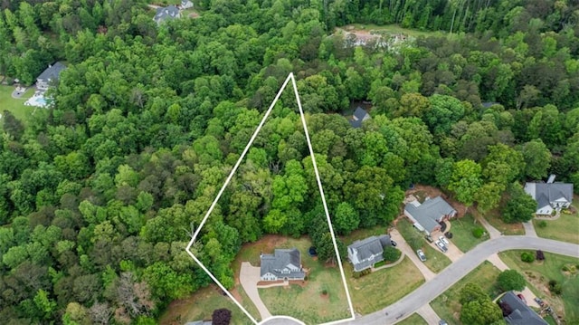 drone / aerial view with a wooded view