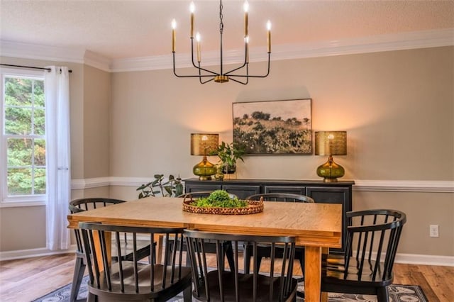 dining space featuring an inviting chandelier, crown molding, a textured ceiling, and wood finished floors