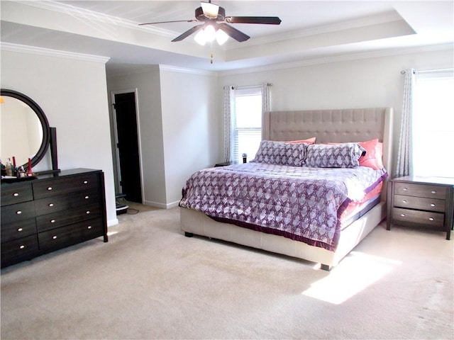 bedroom featuring ornamental molding, a raised ceiling, ceiling fan, and light carpet