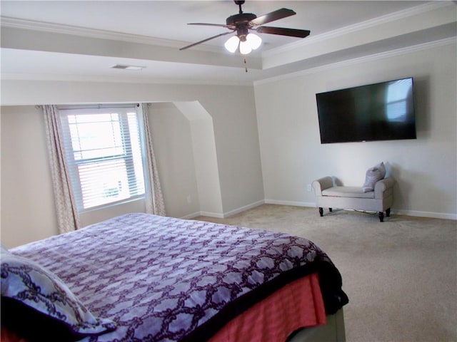 carpeted bedroom with ceiling fan, ornamental molding, and a tray ceiling