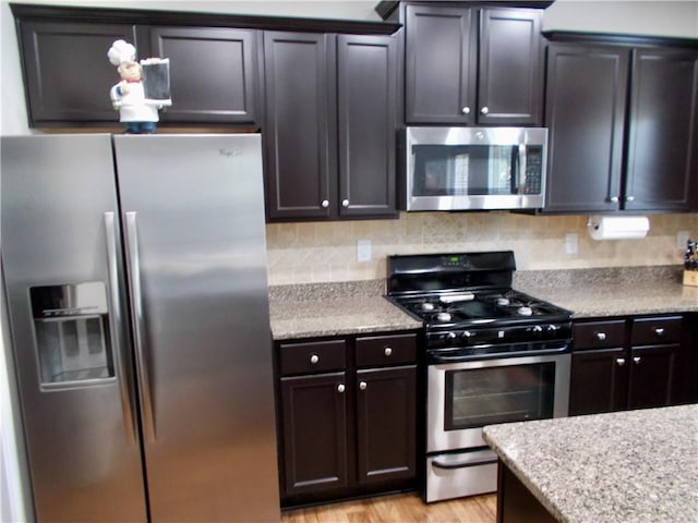 kitchen with stainless steel appliances, light hardwood / wood-style flooring, and dark brown cabinetry