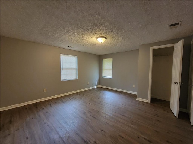 2940 Grand Ave SW, Atlanta, GA 30315 - unfurnished bedroom with visible vents, baseboards, a textured ceiling, and dark wood-style floors