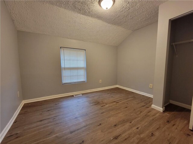 2940 Grand Ave SW, Atlanta, GA 30315 - unfurnished bedroom with baseboards, vaulted ceiling, a textured ceiling, dark wood-type flooring, and visible vents
