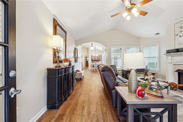 living room featuring lofted ceiling, wood-type flooring, and ceiling fan