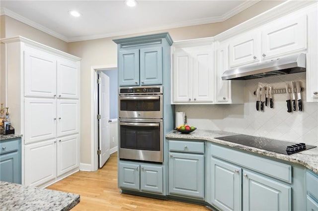 kitchen featuring white cabinets, crown molding, black electric cooktop, light wood-type flooring, and stainless steel double oven