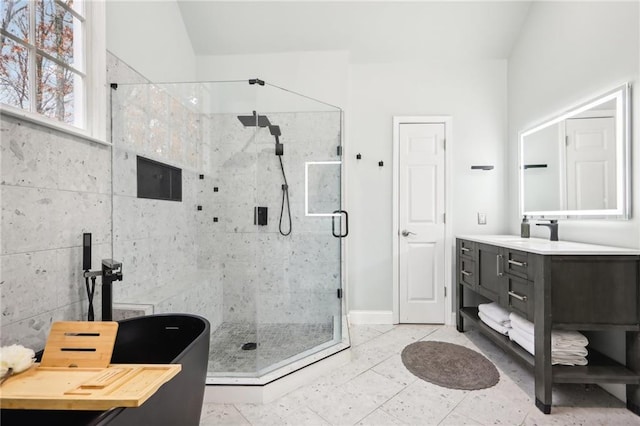 bathroom featuring vanity, vaulted ceiling, tile walls, tile patterned flooring, and a shower with shower door