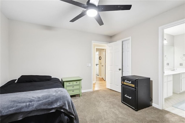 carpeted bedroom with ensuite bathroom and ceiling fan