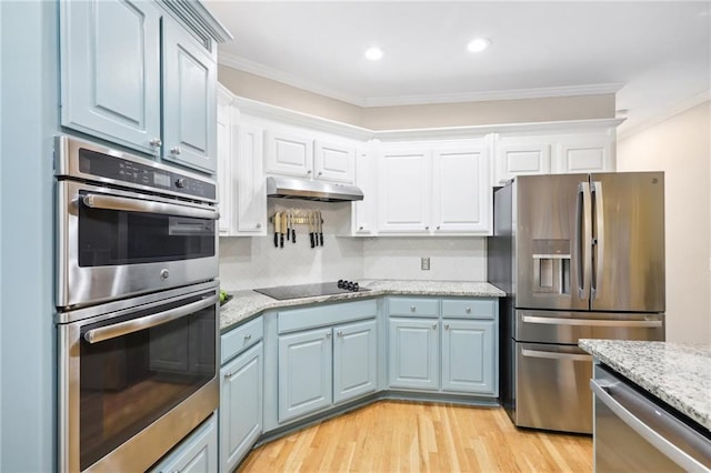 kitchen featuring white cabinetry, light stone counters, light hardwood / wood-style flooring, crown molding, and appliances with stainless steel finishes