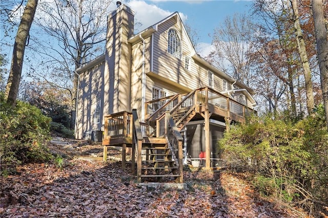 back of property with central air condition unit, a wooden deck, and a sunroom