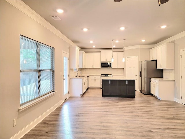 kitchen featuring white cabinets, a center island, pendant lighting, and stainless steel appliances