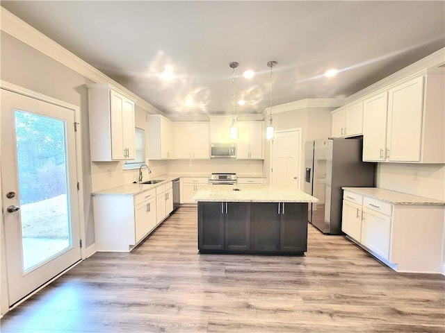 kitchen featuring light stone countertops, white cabinets, a center island, and stainless steel appliances