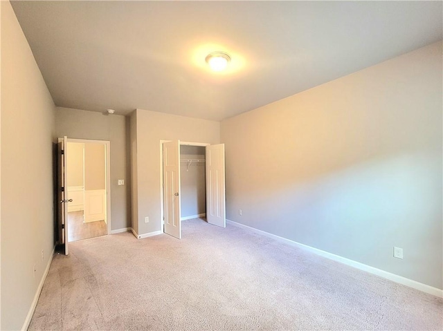 unfurnished bedroom featuring a closet and light carpet