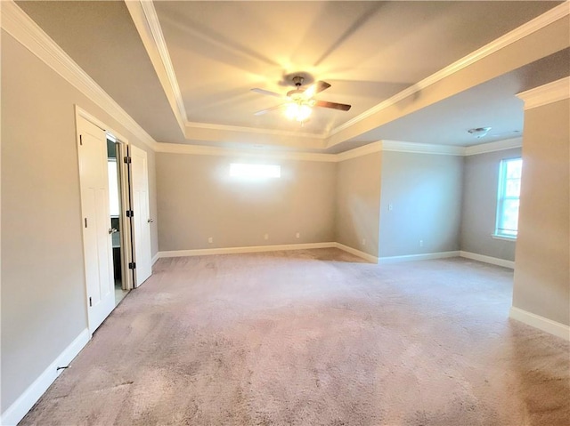 carpeted spare room with ceiling fan, a raised ceiling, and crown molding