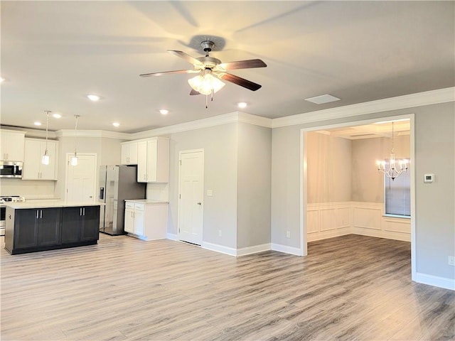 unfurnished living room featuring crown molding, light wood-type flooring, and ceiling fan with notable chandelier