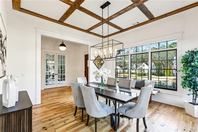 dining space featuring french doors, coffered ceiling, plenty of natural light, and light wood-style flooring