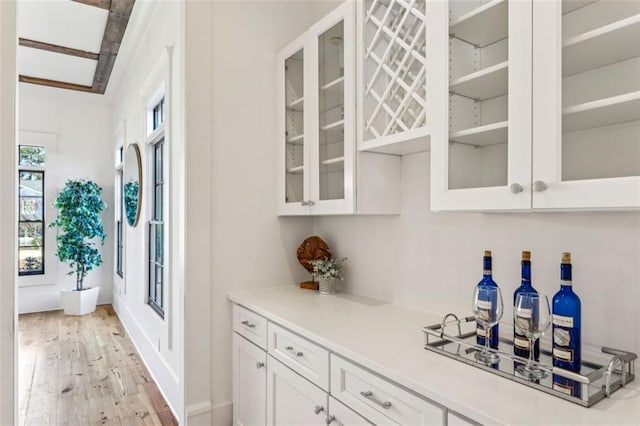 bar with baseboards, black electric stovetop, and light wood-style floors