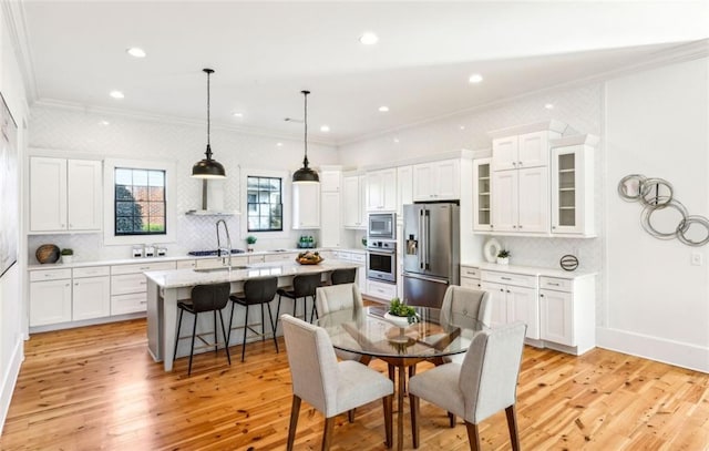 dining space featuring ornamental molding, recessed lighting, light wood-style flooring, and baseboards