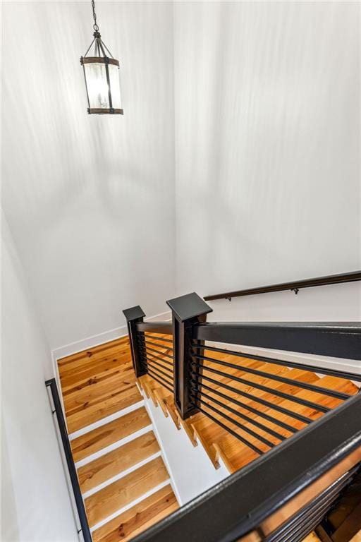 staircase featuring baseboards and wood finished floors